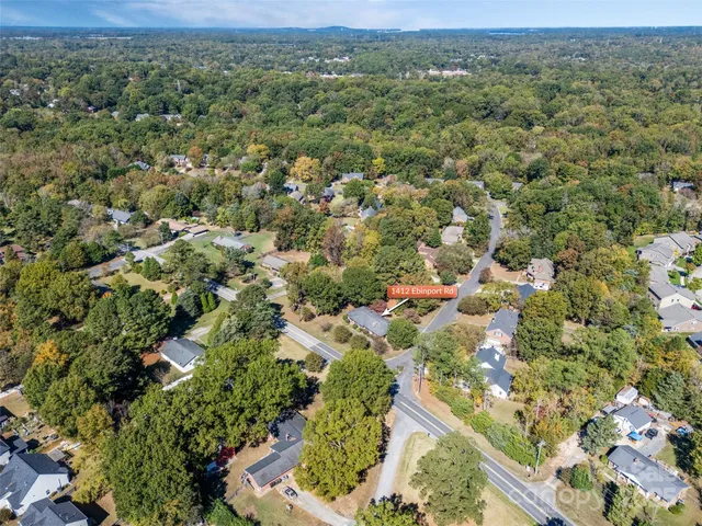 an aerial view of residential houses with outdoor space and trees