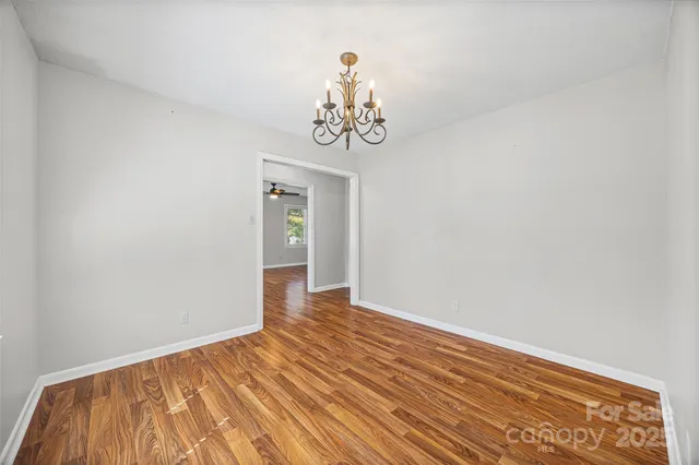 a view of a room with wooden floor and ceiling fan