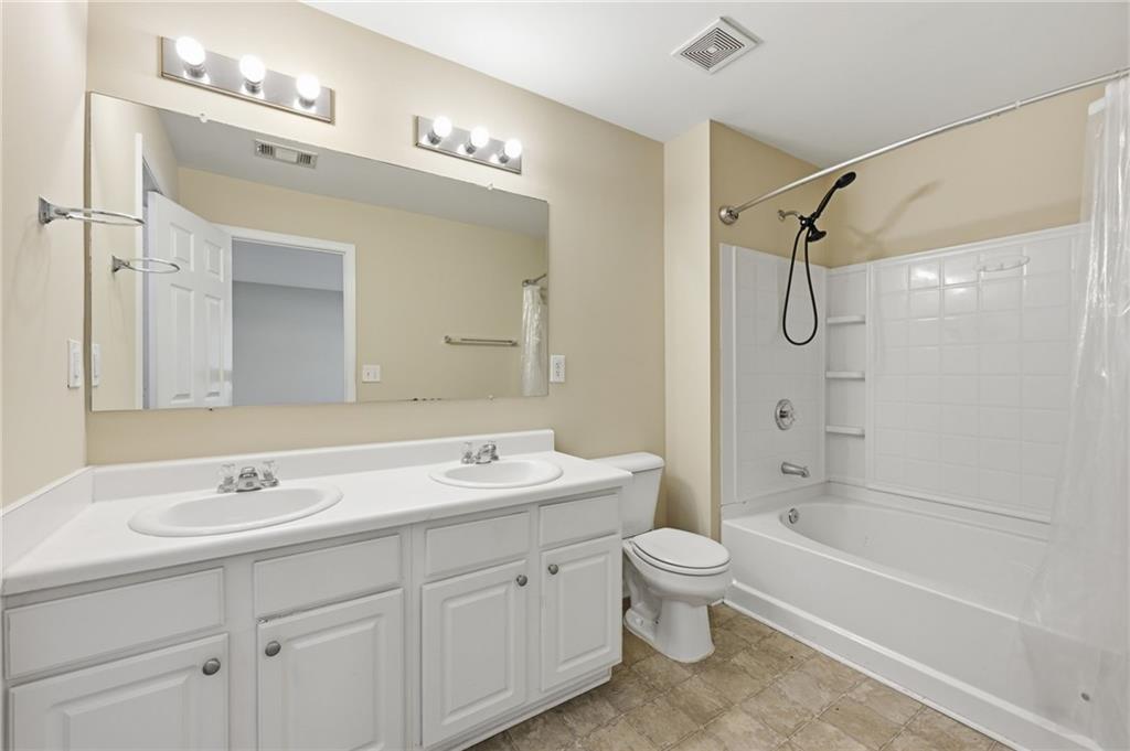2335 Meadow Peak Point Duluth, GA 30097 - Photo 20 of 32 a bathroom with a double vanity sink toilet mirror and bathtub