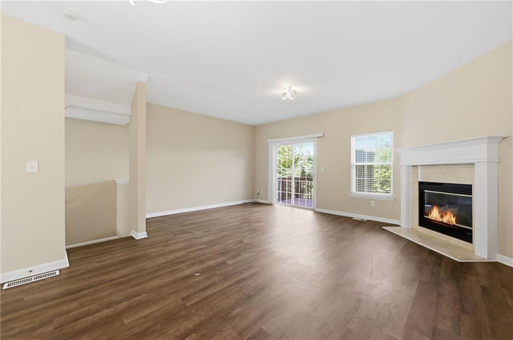 2335 Meadow Peak Point Duluth, GA 30097 - Photo 8 of 32 an empty room with wooden floor fireplace and windows