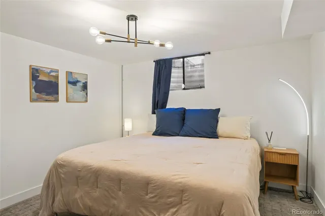 a bedroom with a large bed and a chandelier