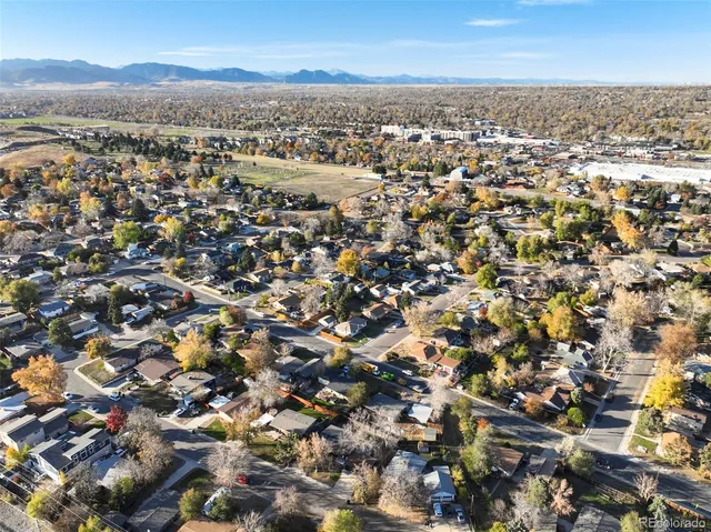 an aerial view of residential houses with outdoor space and trees