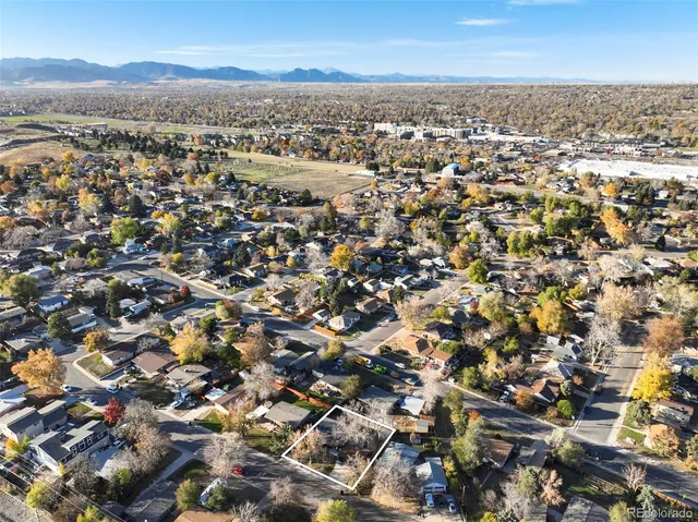 an aerial view of residential houses with outdoor space and trees