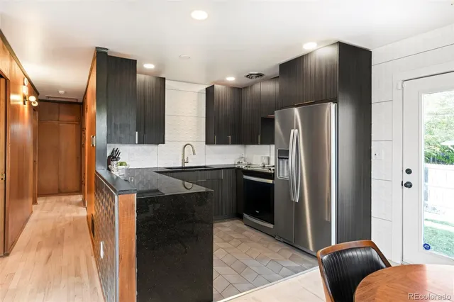 a kitchen with stainless steel appliances granite countertop a refrigerator a sink and a stove