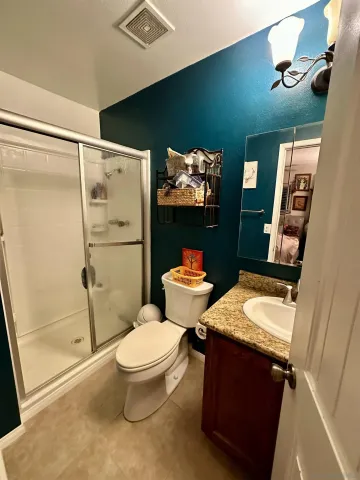 a bathroom with a granite countertop toilet sink and shower