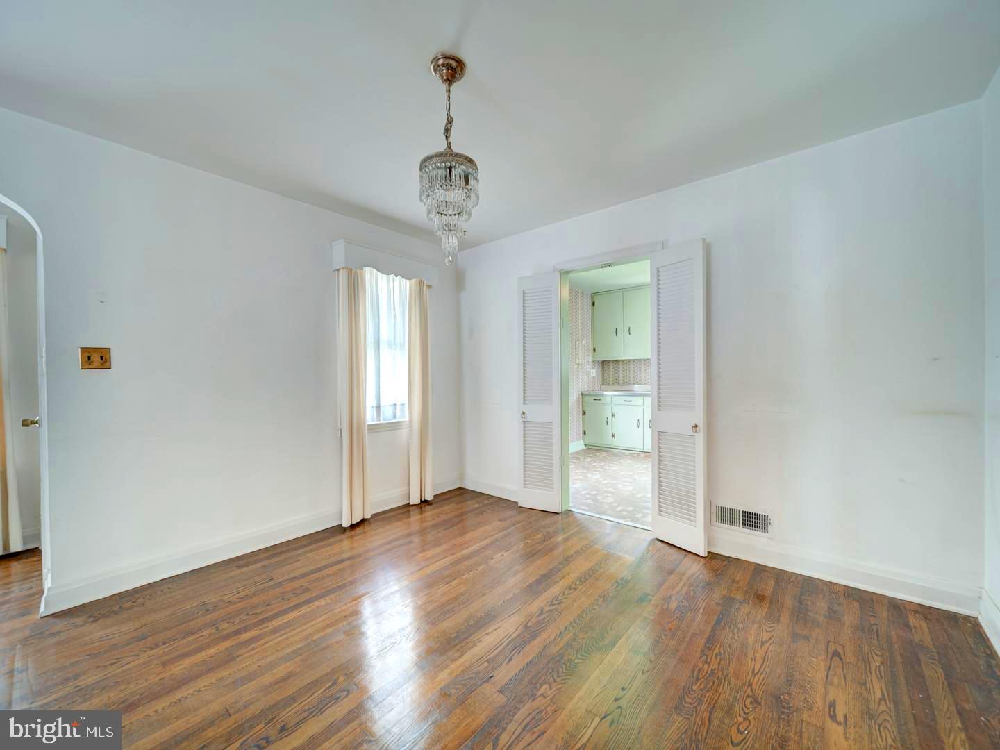 6505 Beechwood Road Baltimore, MD 21239 - Photo 12 of 46 a view of an empty room with wooden floor and a window