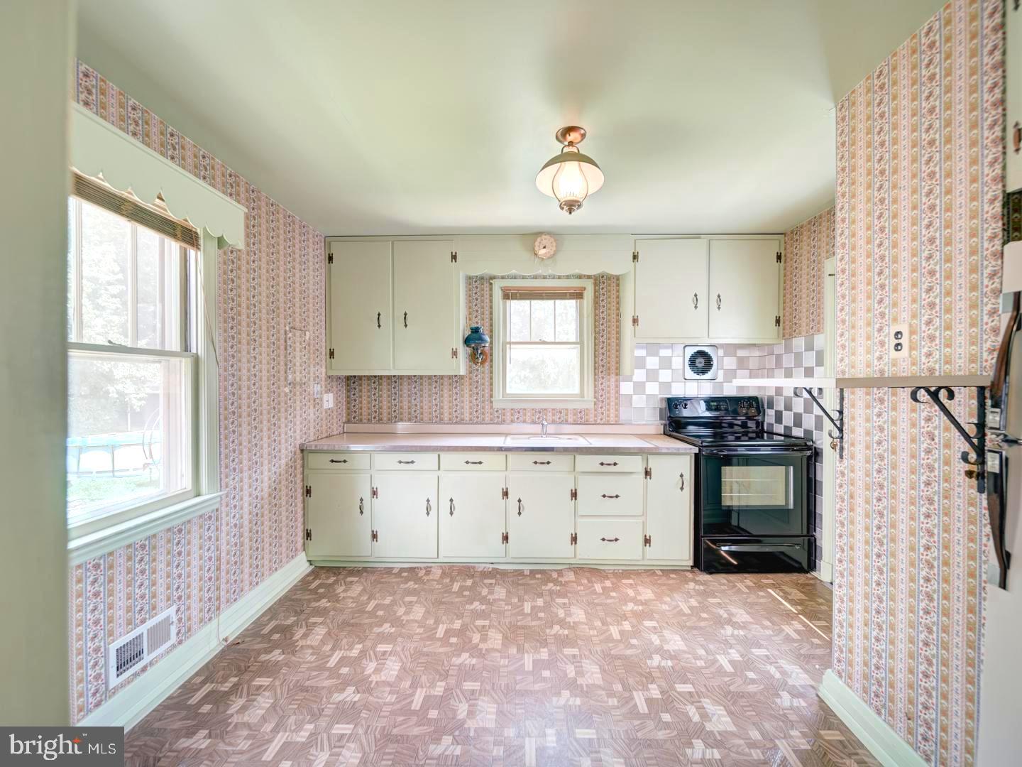 6505 Beechwood Road Baltimore, MD 21239 - Photo 13 of 46 a kitchen with granite countertop a stove a sink a window and a dining table