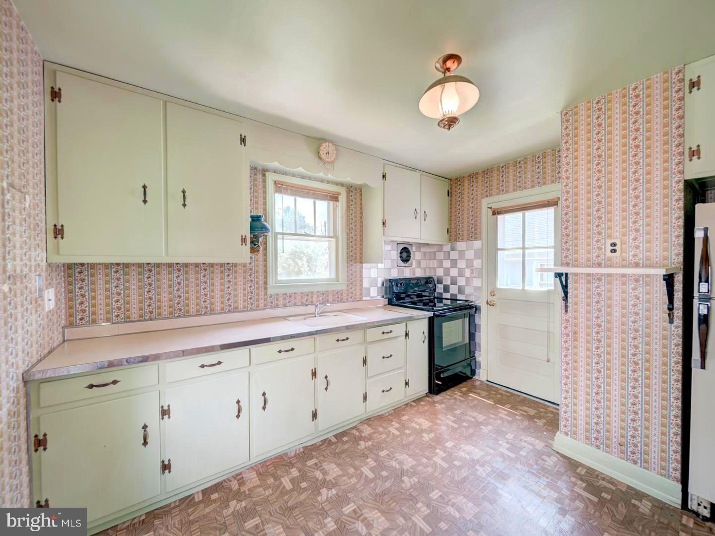 6505 Beechwood Road Baltimore, MD 21239 - Photo 14 of 46 a kitchen with granite countertop white cabinets and white appliances