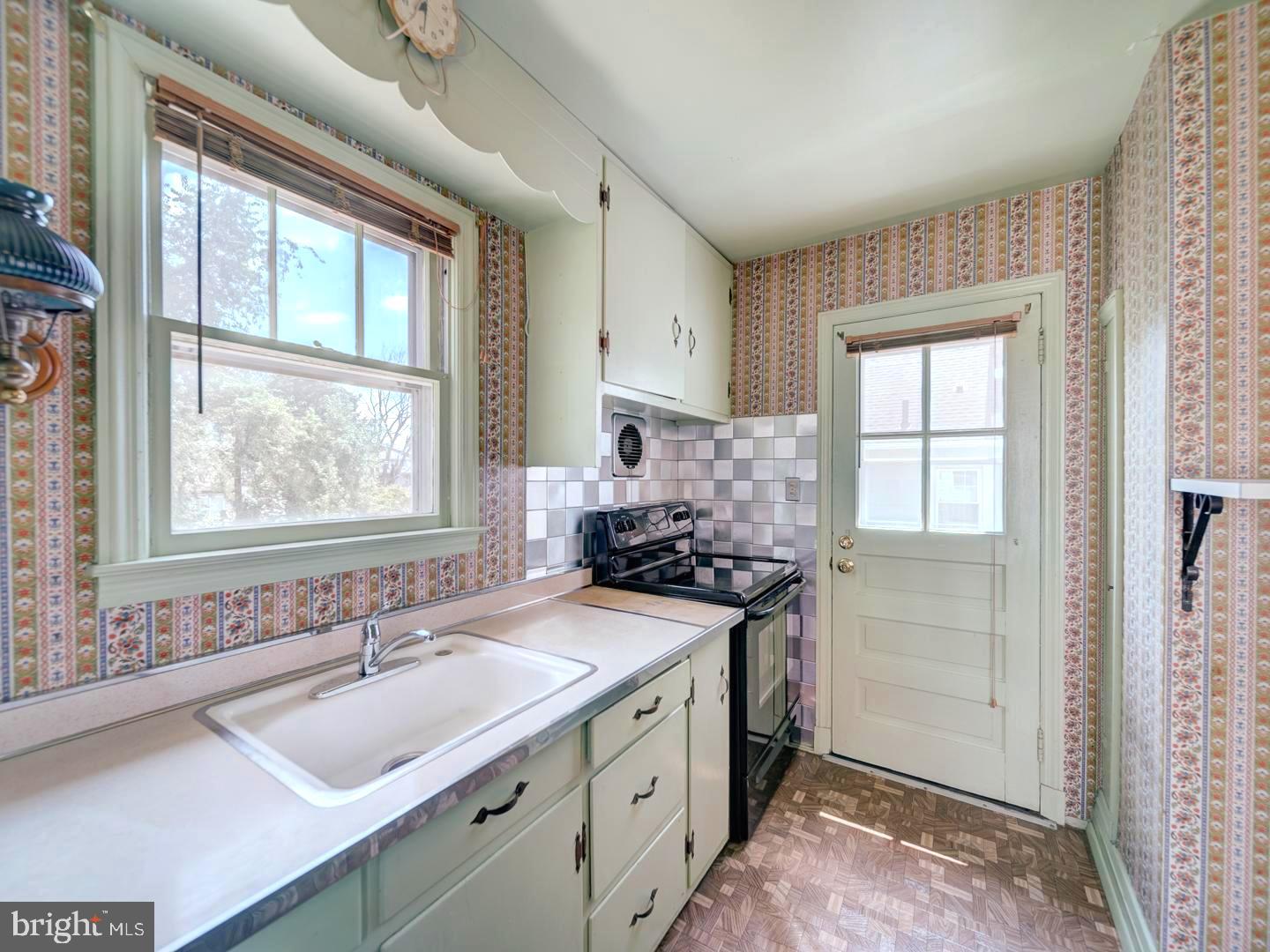 6505 Beechwood Road Baltimore, MD 21239 - Photo 16 of 46 a kitchen with a sink stove top oven and cabinets