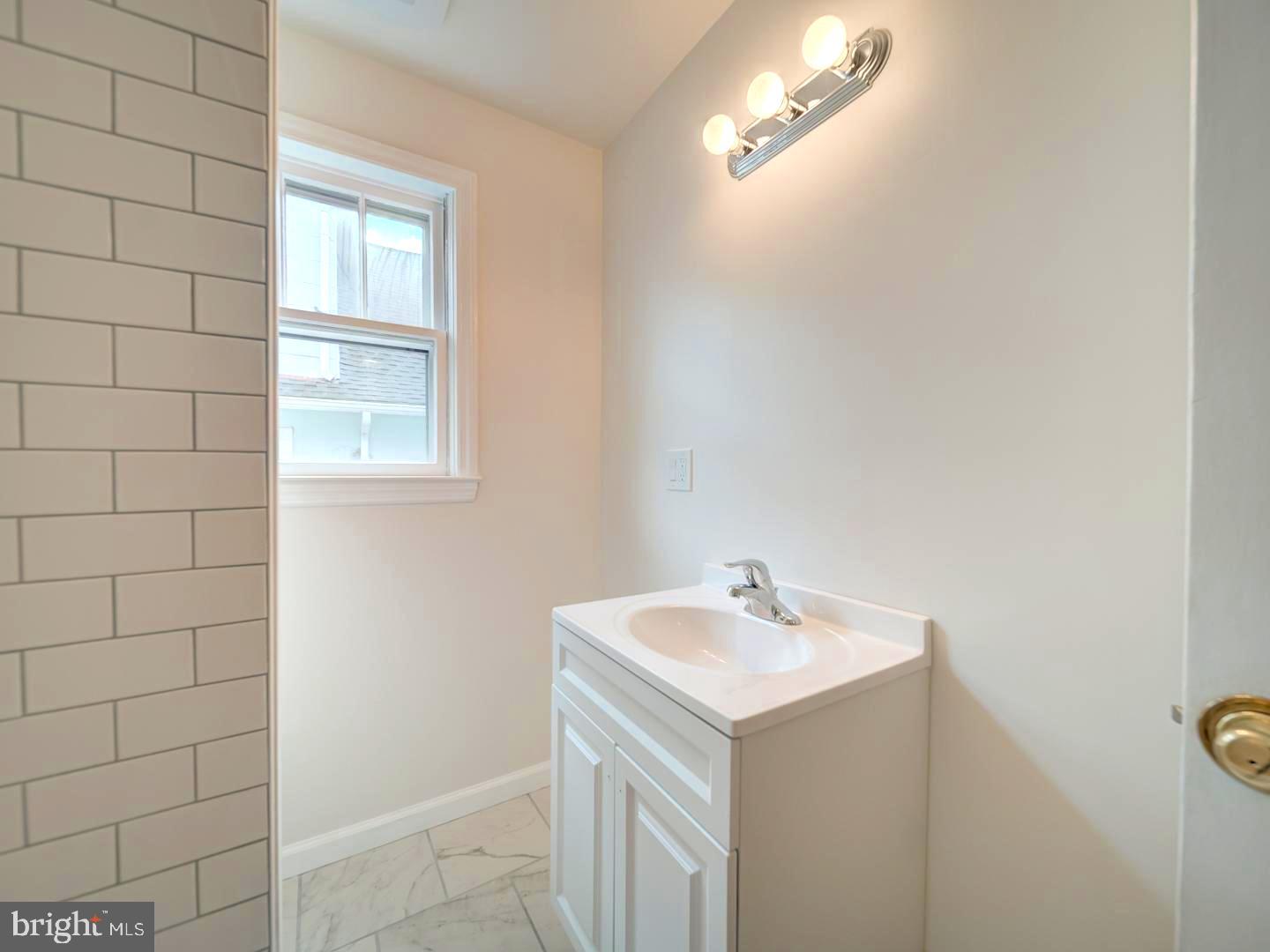 6505 Beechwood Road Baltimore, MD 21239 - Photo 22 of 46 a bathroom with a sink a vanity and a mirror