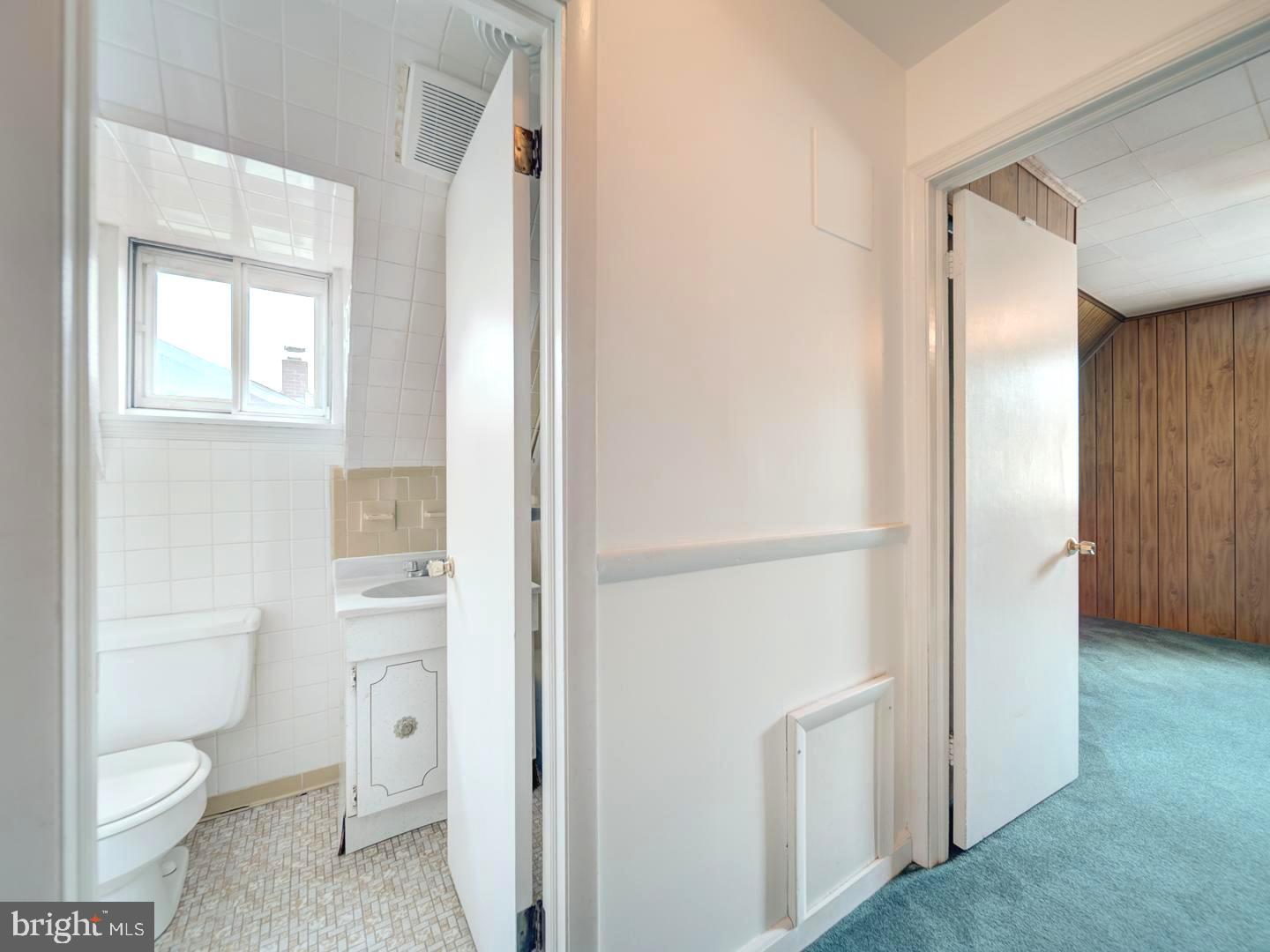 6505 Beechwood Road Baltimore, MD 21239 - Photo 37 of 46 a bathroom with a toilet sink and a mirror
