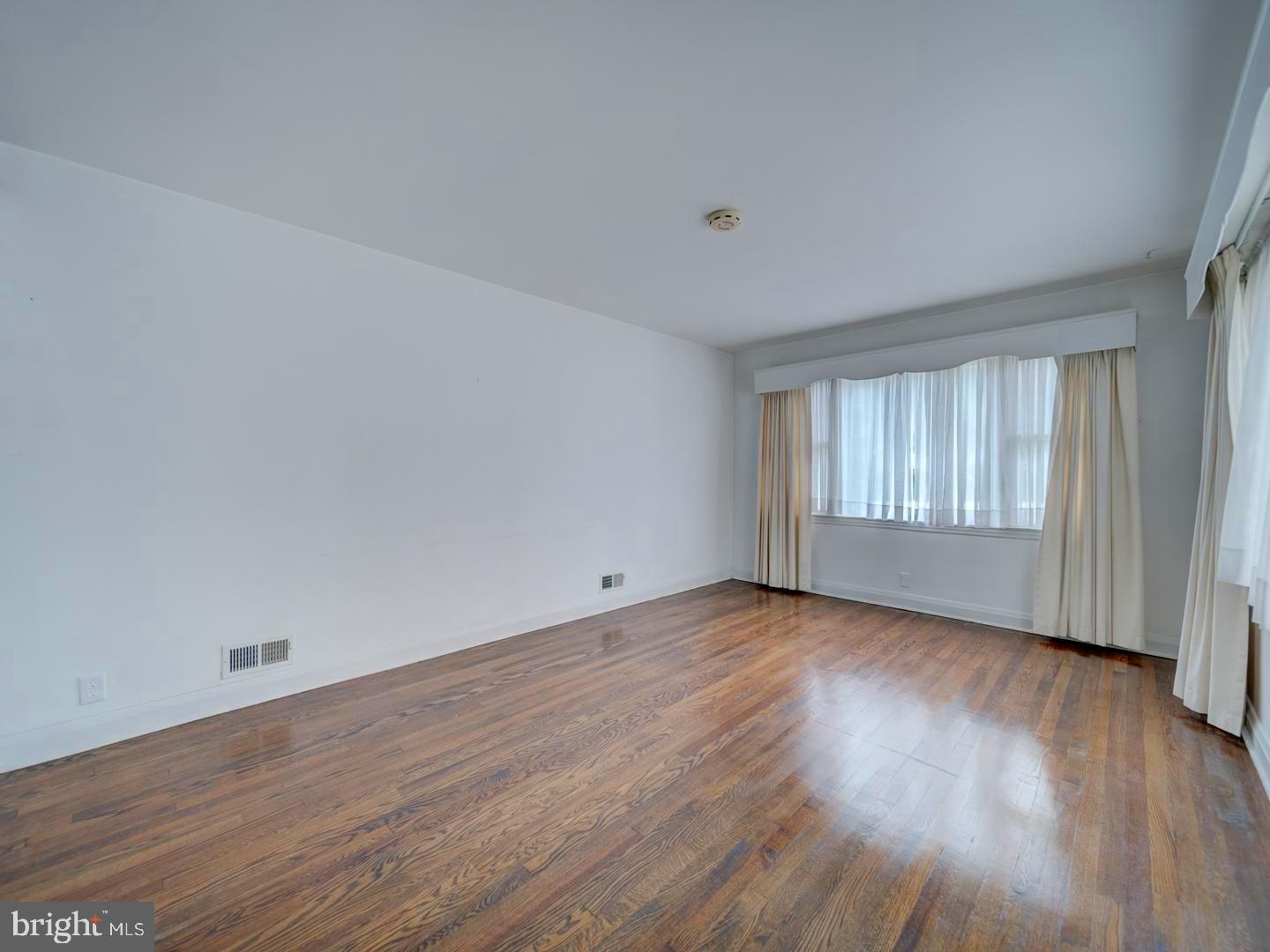 6505 Beechwood Road Baltimore, MD 21239 - Photo 5 of 46 a view of an empty room with wooden floor and window