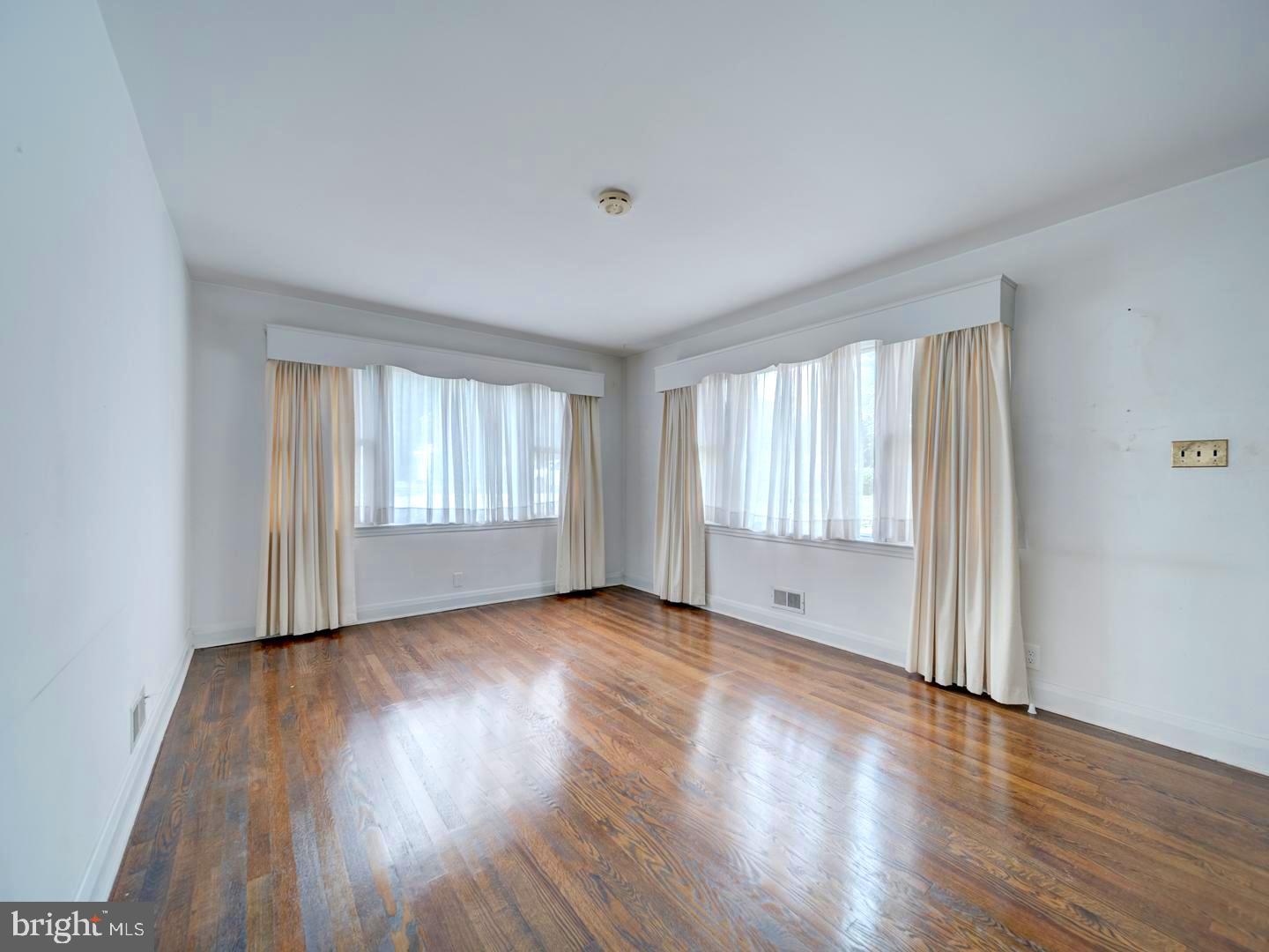 6505 Beechwood Road Baltimore, MD 21239 - Photo 6 of 46 a view of an empty room with wooden floor and a window