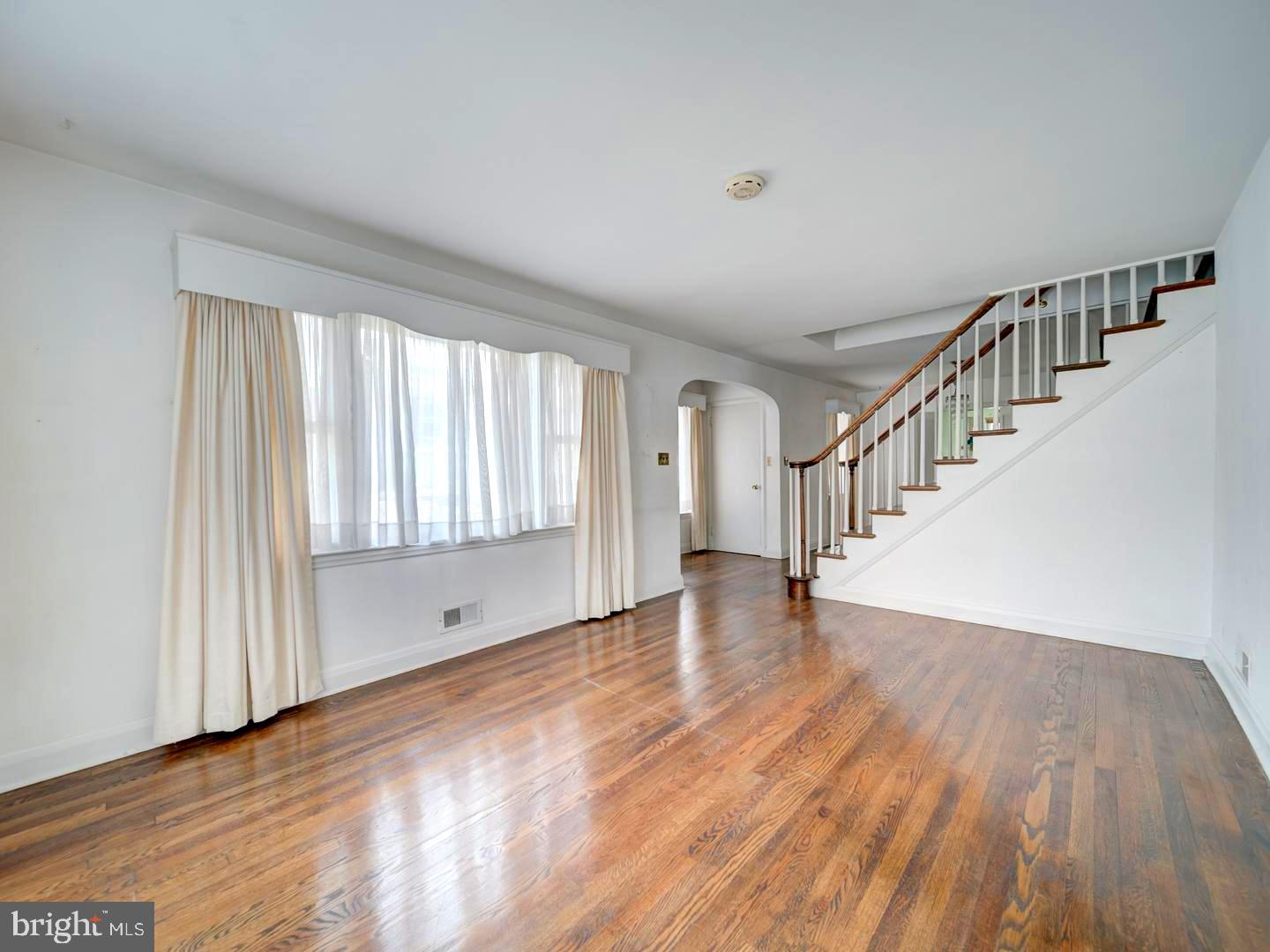 6505 Beechwood Road Baltimore, MD 21239 - Photo 7 of 46 a view of an empty room with wooden floor and a window