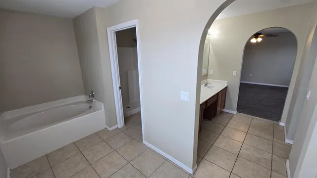 an empty room with a chandelier fan and a window