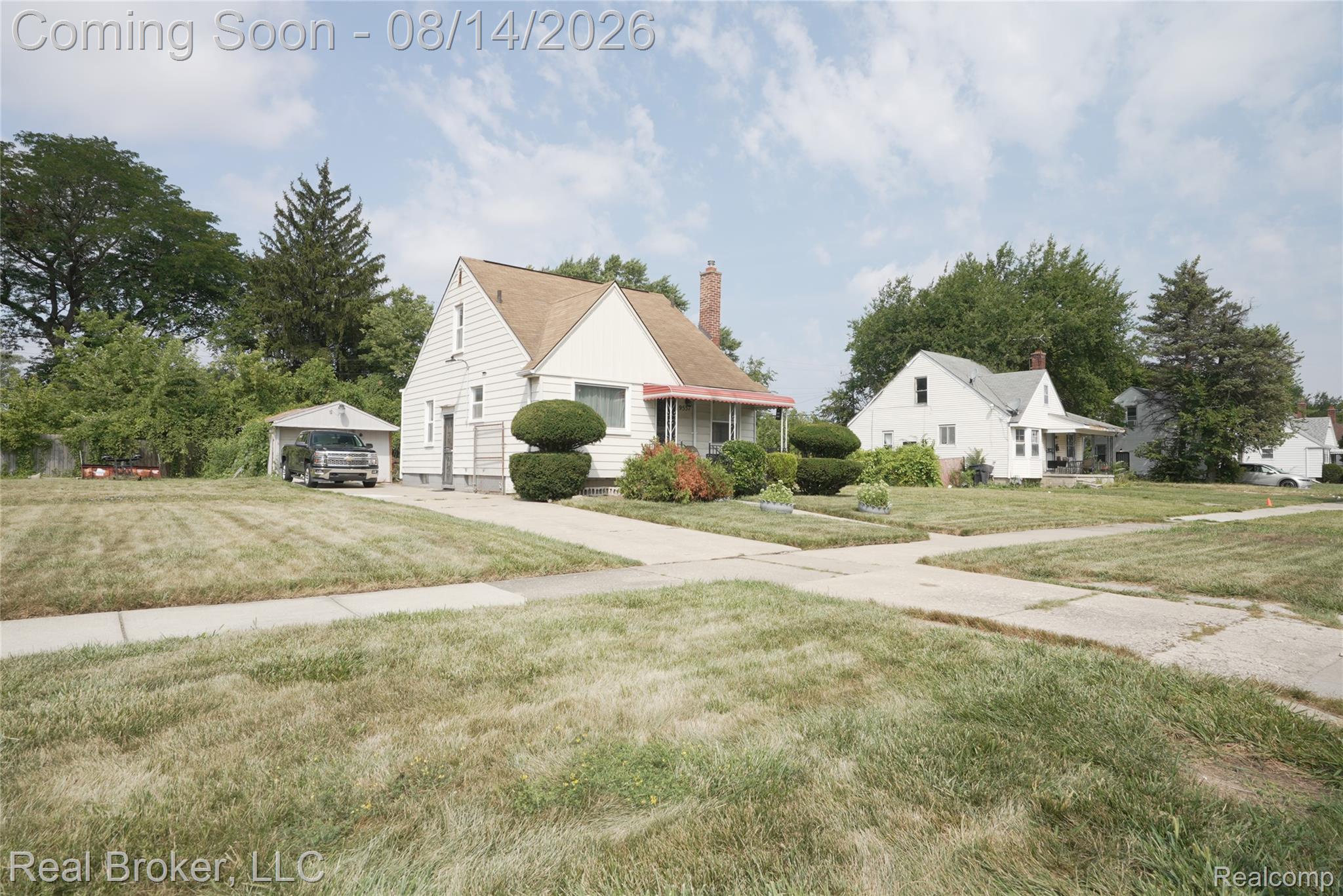 9557 Meyers Road Detroit, MI 48227 - Photo 7 of 23 White siding exterior with a brown shingle roof, a detached garage, and a concrete driveway