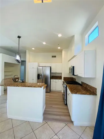 a large kitchen with stainless steel appliances kitchen island a large counter top a stove and a sink