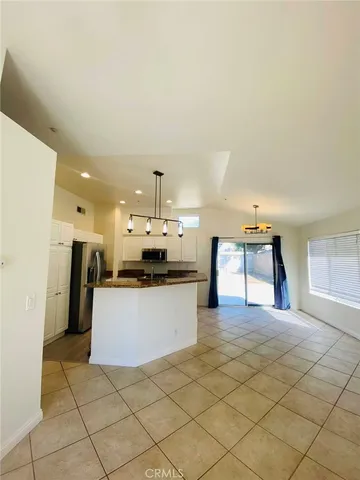a large kitchen with kitchen island white cabinets and stainless steel appliances