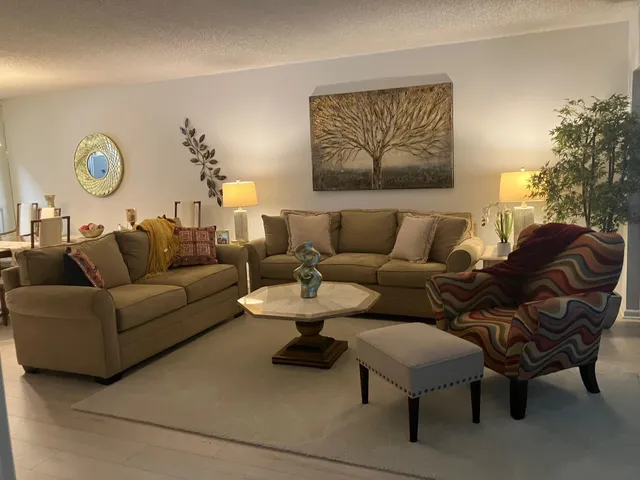 a living room with furniture a rug and a wall painting