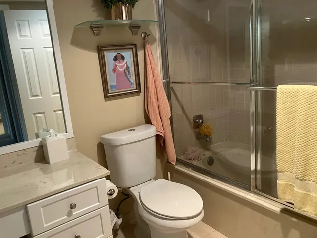 a bathroom with a granite countertop sink toilet and a shower