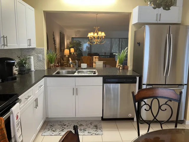 a kitchen with stainless steel appliances granite countertop a refrigerator and a stove