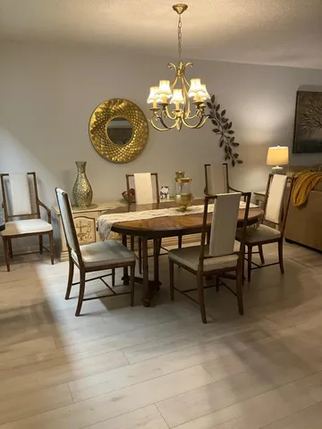 a view of a dining room with furniture a chandelier and wooden floor