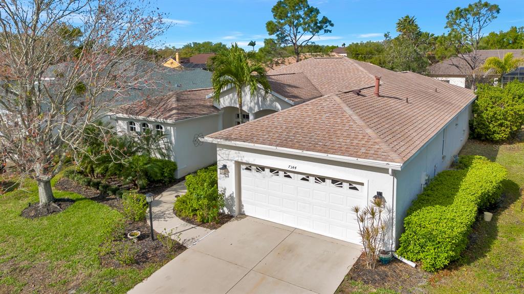 7344 Arrowhead Run Lakewood Ranch, FL 34202 - Photo 20 of 24 a view of a house with a yard and potted plants