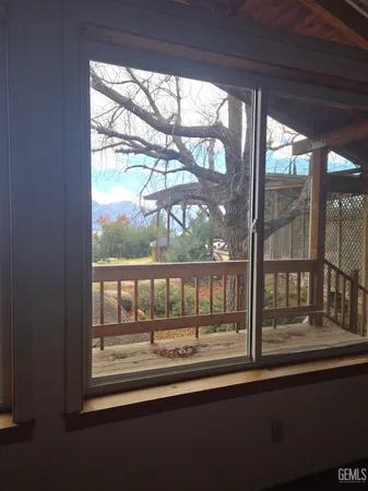 an empty room with windows and ceiling fan