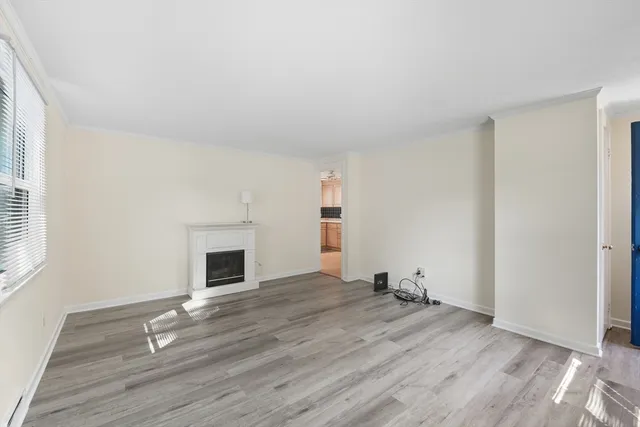 an empty room with wooden floor and fireplace