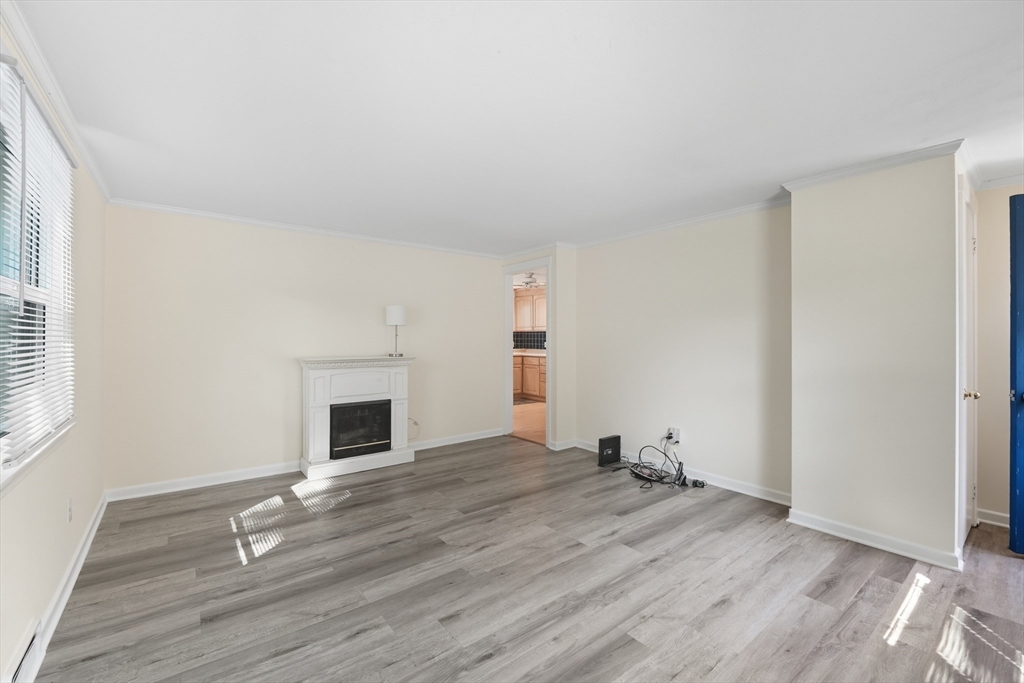 86 Talmadge Drive Springfield, MA 01118 - Photo 6 of 33 an empty room with wooden floor and fireplace