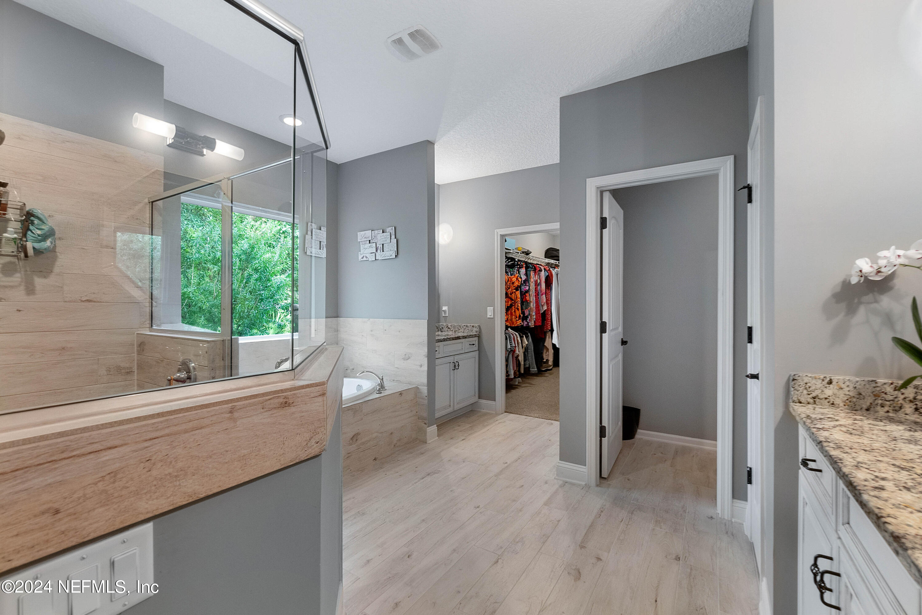 847 Oak Ridge Road St. Augustine, FL 32086 - Photo 16 of 36 a bathroom with a granite countertop sink a large mirror and a bathtub