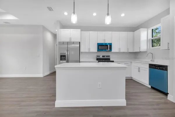 a kitchen with kitchen island white cabinets and stainless steel appliances