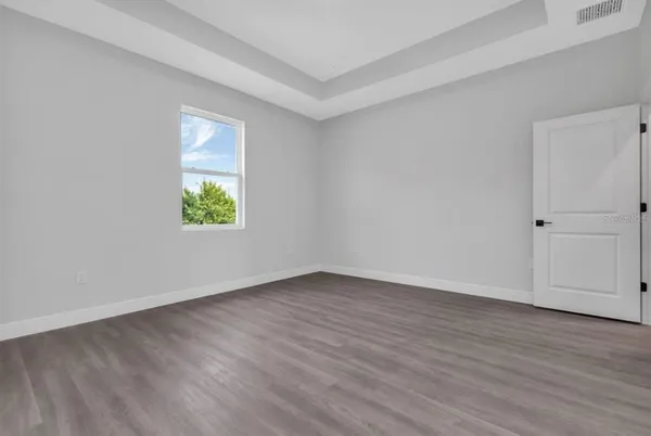 an empty room with wooden floor and a window