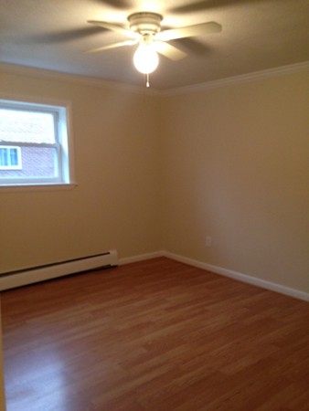 76 Bryon Road, Unit 3 Boston, MA 02467 - Photo 3 of 7 a view of an empty room with wooden floor and a window