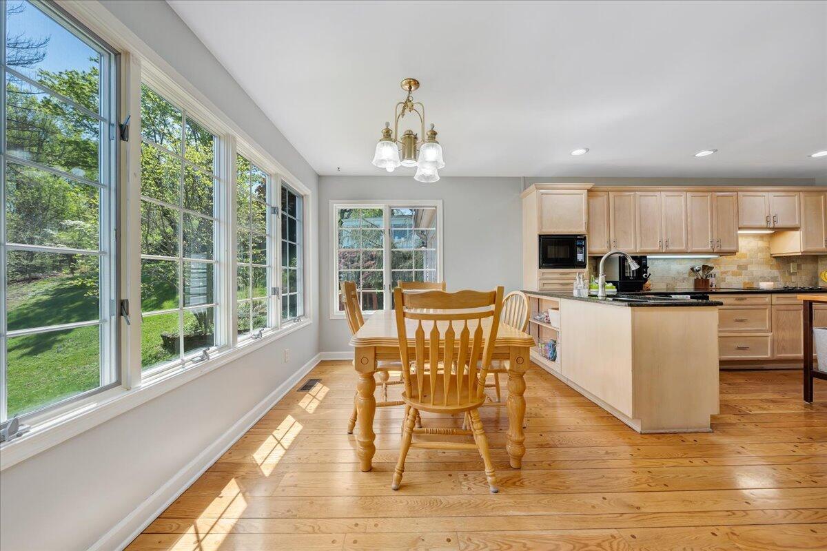 5586 Highfields Road Roanoke, VA 24018 - Photo 8 of 29 a dining room with wooden floor a chandelier a glass table and chairs