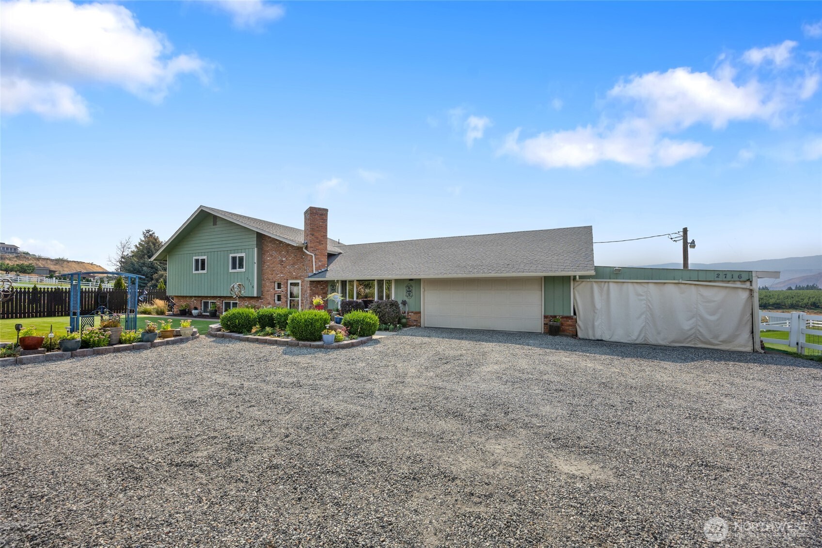 2716 8th Street Northeast East Wenatchee, WA 98802 - Photo 2 of 40 a front view of a house with a yard and garage