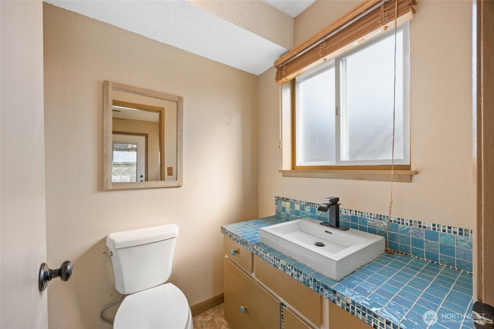 2716 8th Street Northeast East Wenatchee, WA 98802 - Photo 26 of 40 a bathroom with a toilet a sink a mirror and a window
