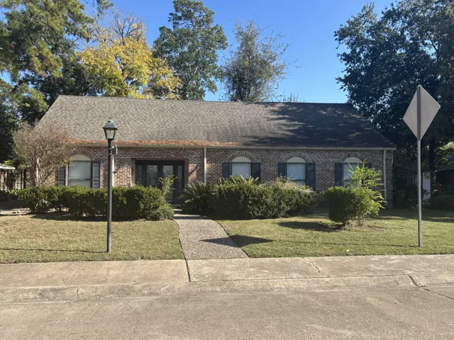 a view of house in front of a yard with potted plants
