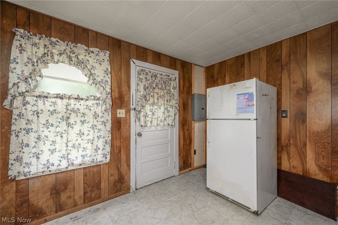 8386 Yale Road Rootstown, OH 44272 - Photo 3 of 46 Wood-panel walls, white painted door, window, and patterned flooring