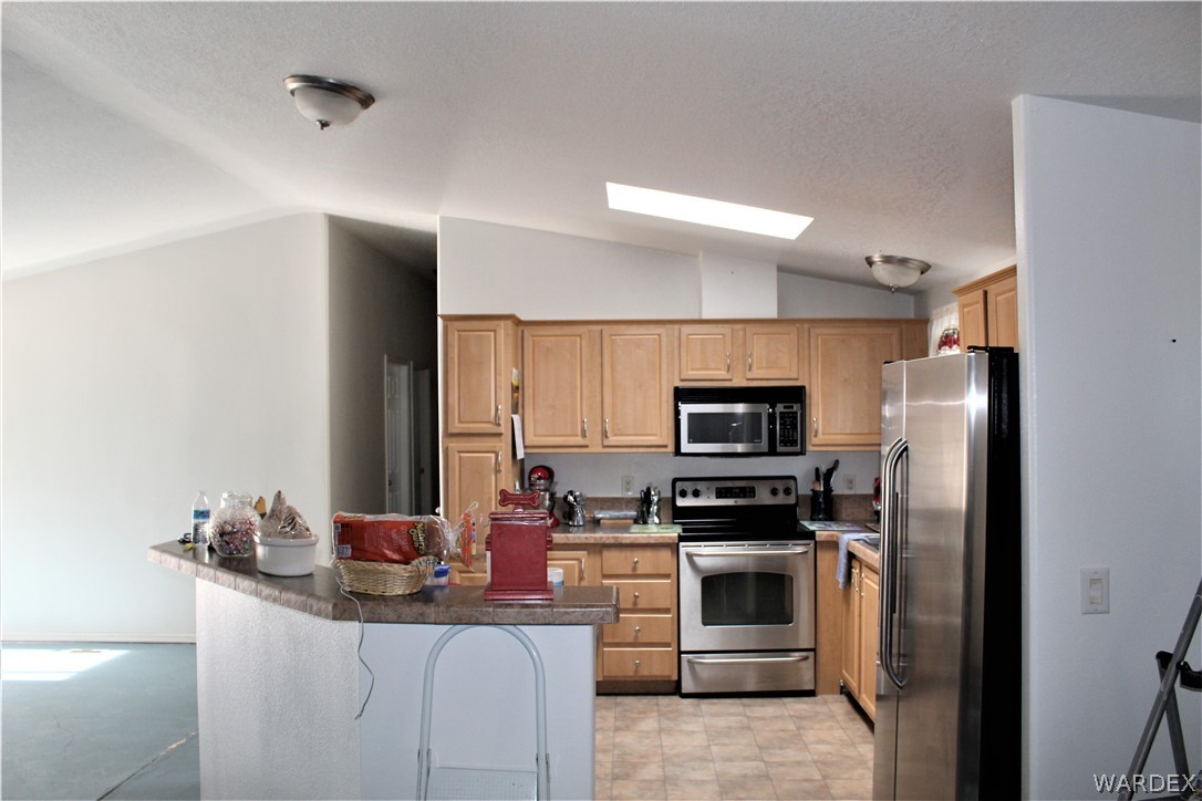 1950 Growler Road Golden Valley, AZ 86413 - Photo 32 of 42 a kitchen with kitchen island a counter top space stainless steel appliances and cabinets