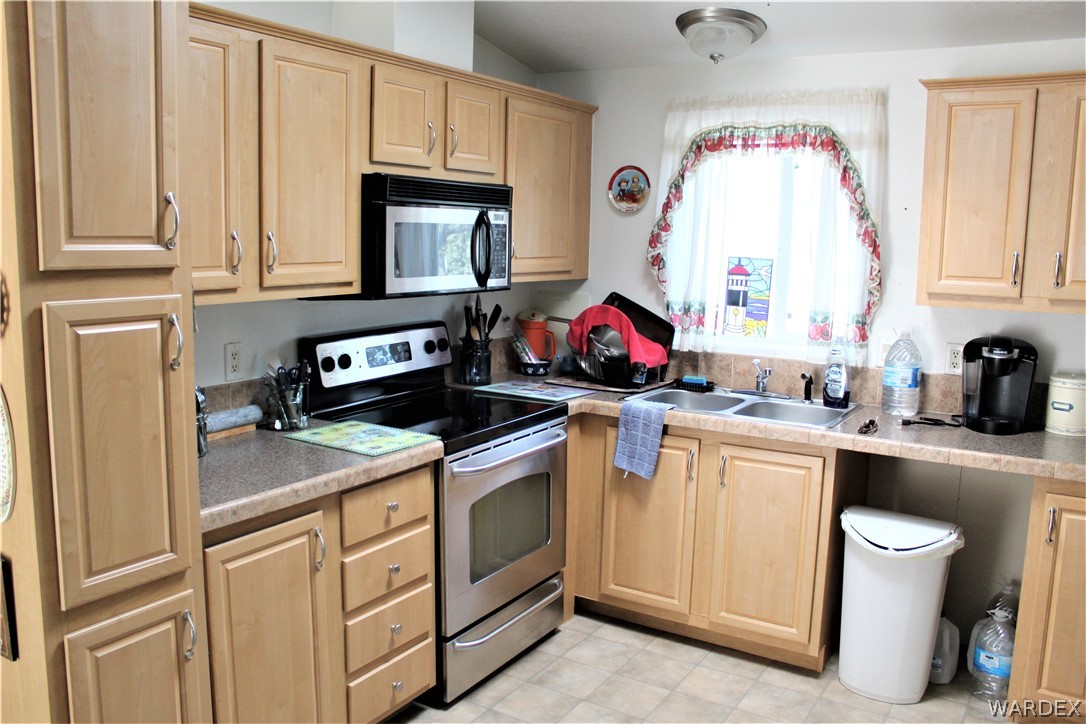 1950 Growler Road Golden Valley, AZ 86413 - Photo 34 of 42 a kitchen with white cabinets and white appliances