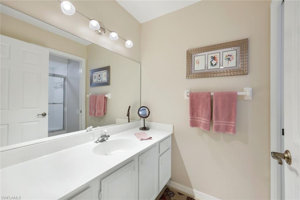 13201 Sherburne Circle, Unit 102 Bonita Springs, FL 34135 - Photo 10 of 22 a bathroom with a sink and a mirror
