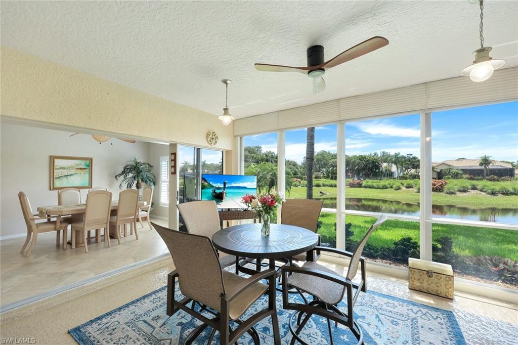 13201 Sherburne Circle, Unit 102 Bonita Springs, FL 34135 - Photo 15 of 22 a dining room with furniture a chandelier and a floor to ceiling window