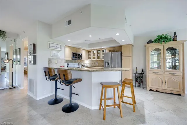 a kitchen with stainless steel appliances granite countertop a refrigerator and a sink