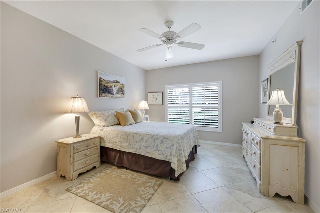 13201 Sherburne Circle, Unit 102 Bonita Springs, FL 34135 - Photo 8 of 22 a bedroom with a bed and a chandelier