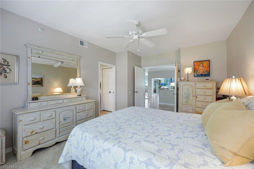 13201 Sherburne Circle, Unit 102 Bonita Springs, FL 34135 - Photo 9 of 22 a bedroom with a bed and a chandelier