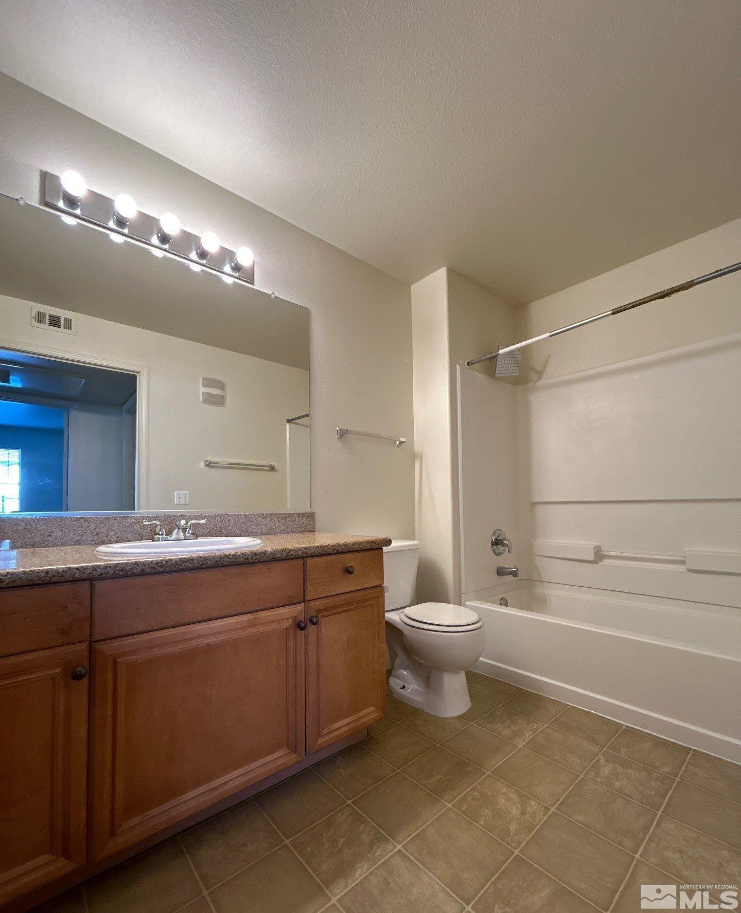 2000 Silverada Boulevard, Unit 112 Reno, NV 89512 - Photo 18 of 19 a bathroom with a toilet sink and mirror