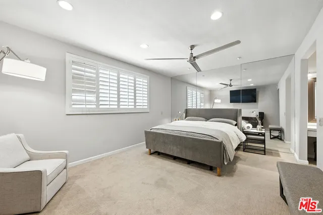 a spacious bedroom with a bed couch and a window