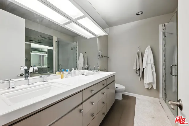 a bathroom with a double vanity sink mirror and shower