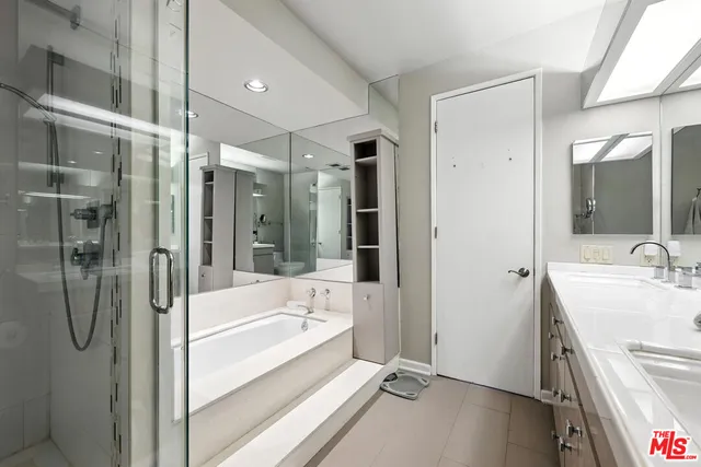 a bathroom with a tub sink shower and mirror